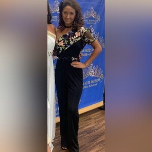 Small adult one piece black jumpsuit with flower accent comes with accessories